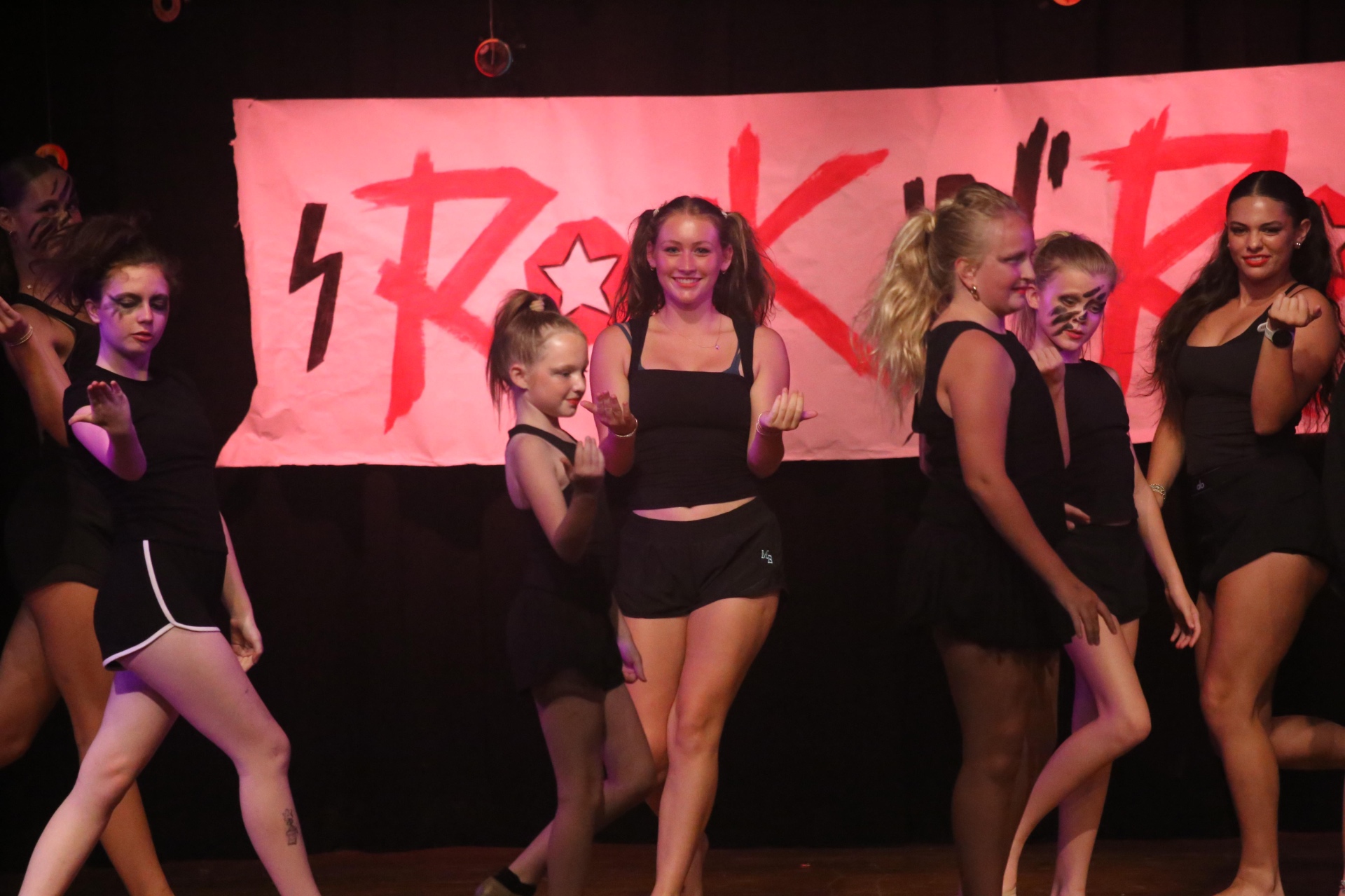 Callie Chapman performing in a lip sync battle on stage at Camp Greystone with dancers and a Shrek-themed backdrop